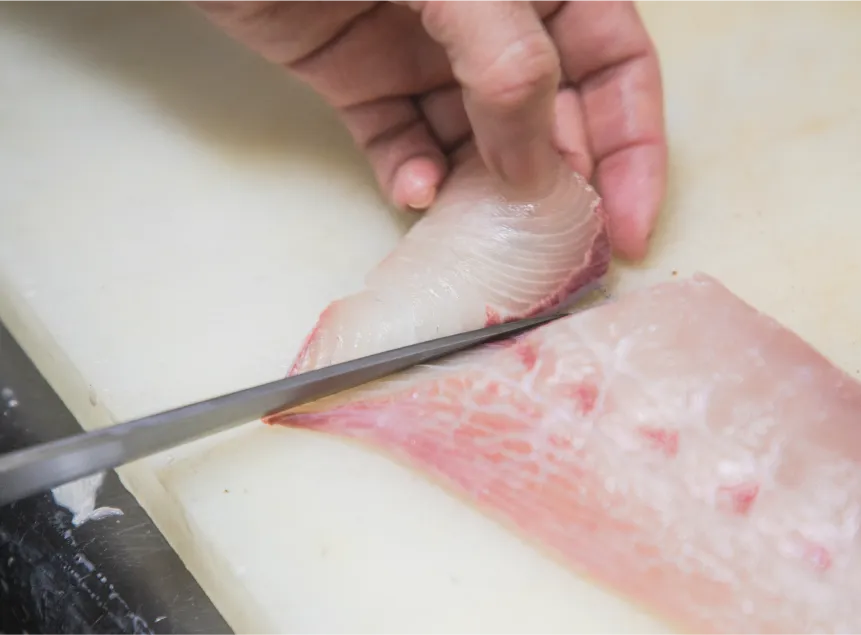 魚をさばく料理人の手元